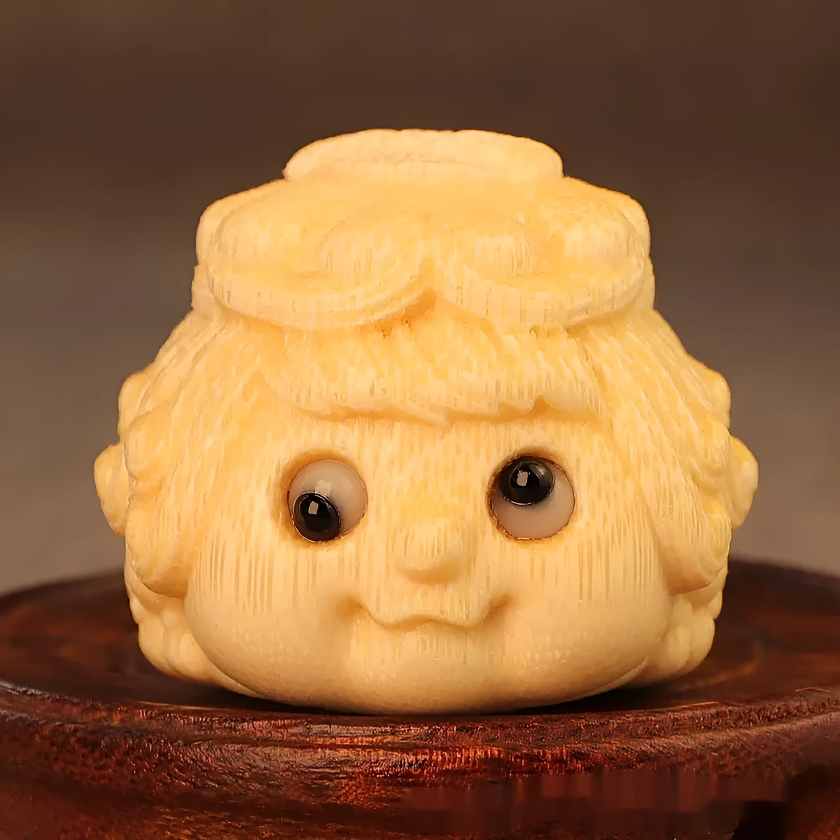Solid bamboo carving of a cute Golden Toad Princess ornament on a neutral background.