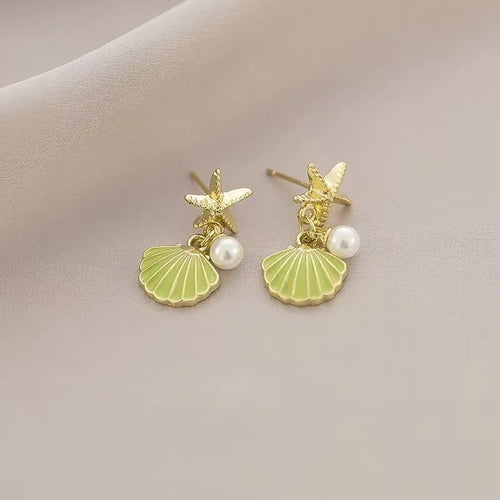 14K gold starfish shell earrings in light green on a white background