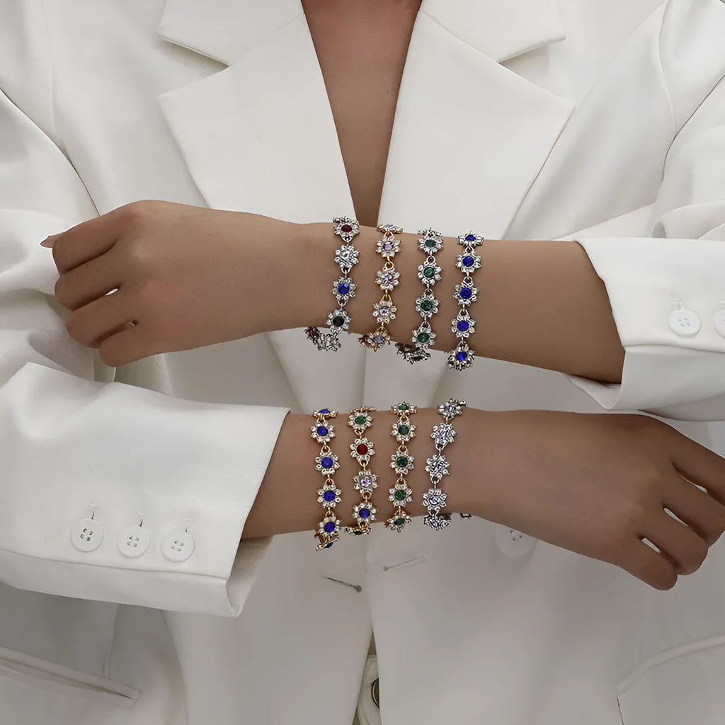 Gold and silver flower bracelet with colourful crystal and simulated diamond stones on a wrist.