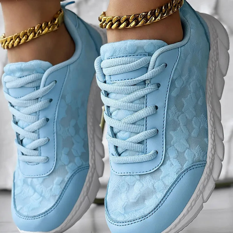 Women's canvas running shoes in white, black, blue, and pink colours with flat-heel construction