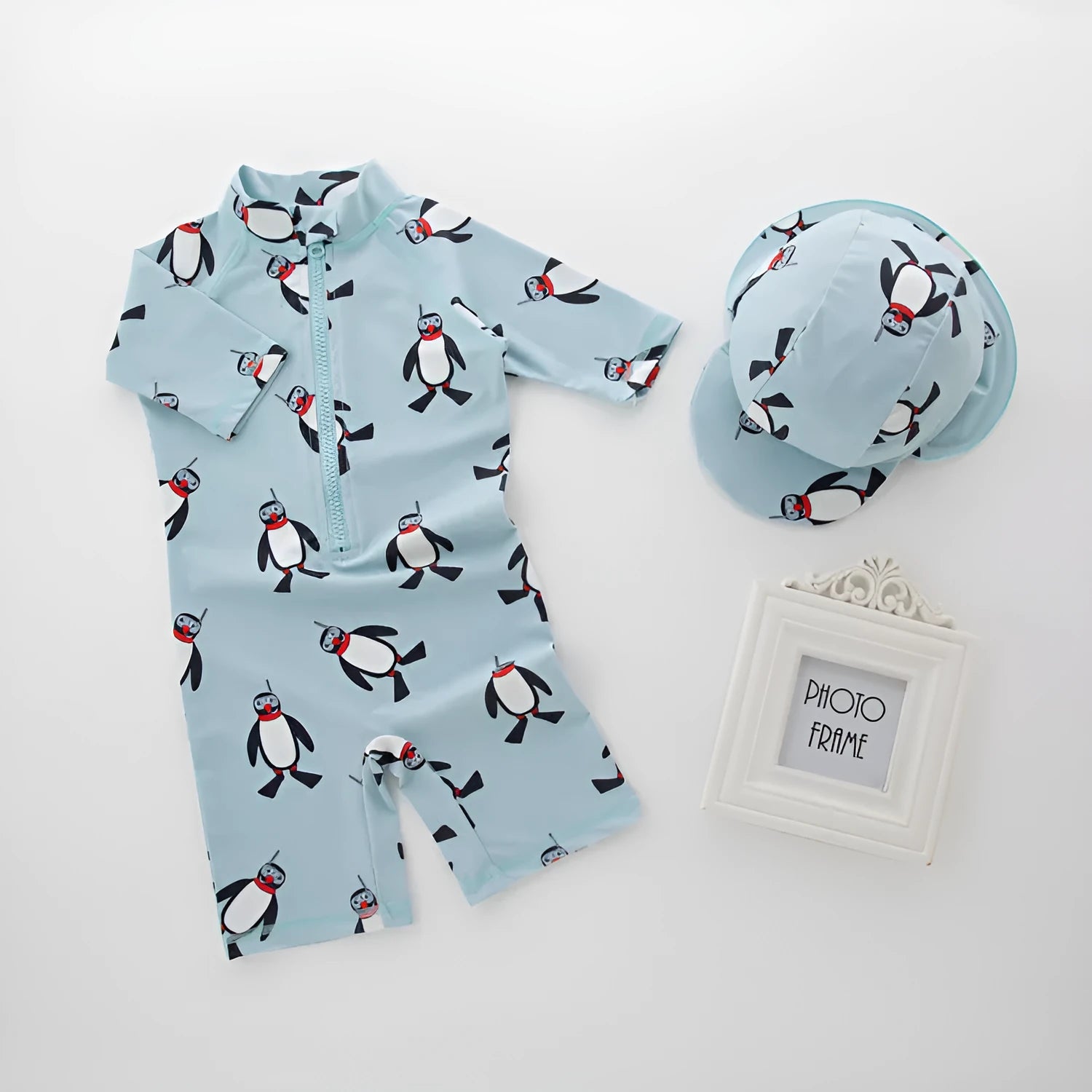 Boy's penguin print long sleeve swimsuit with matching swimming cap set on white background