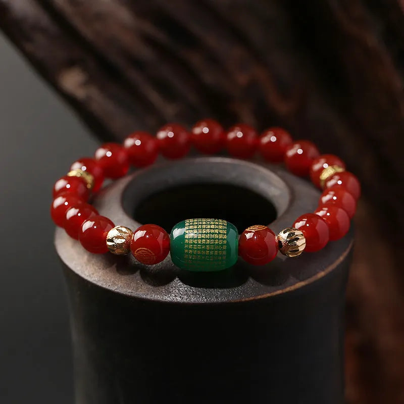 Close-up of a red agate Guanyin bracelet with detailed rosary bead edging on a wrist.