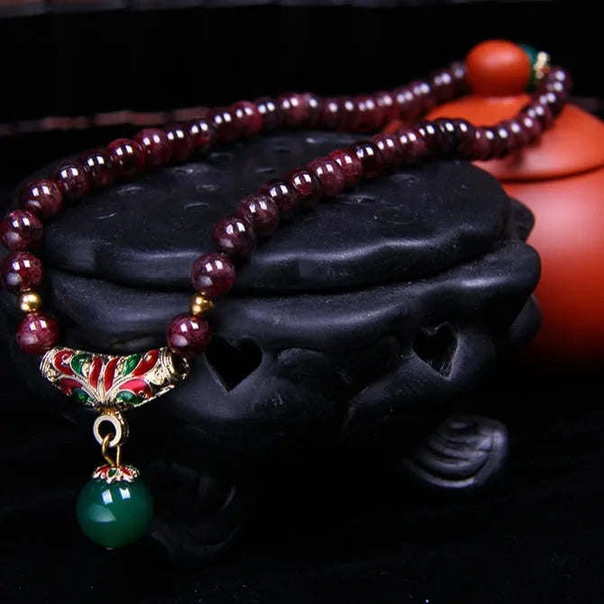 Natural garnet bracelet with 7mm beads, double gold ring clasp, and golden toad charm.