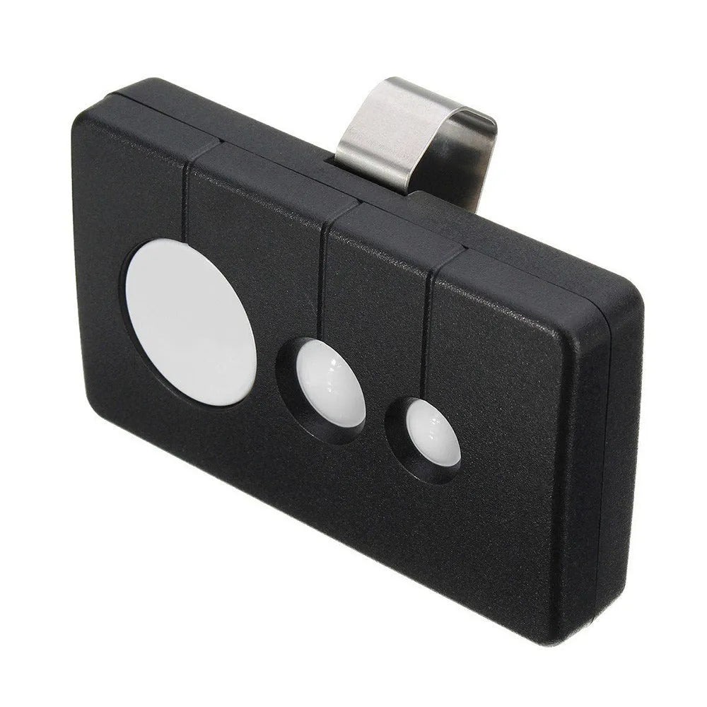 Black plastic three-button garage door remote control next to a CR2032 battery.