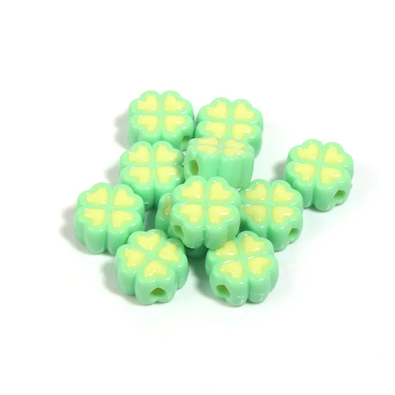 Frosted acrylic four-leaf clover shaped beads in mixed colours on white background