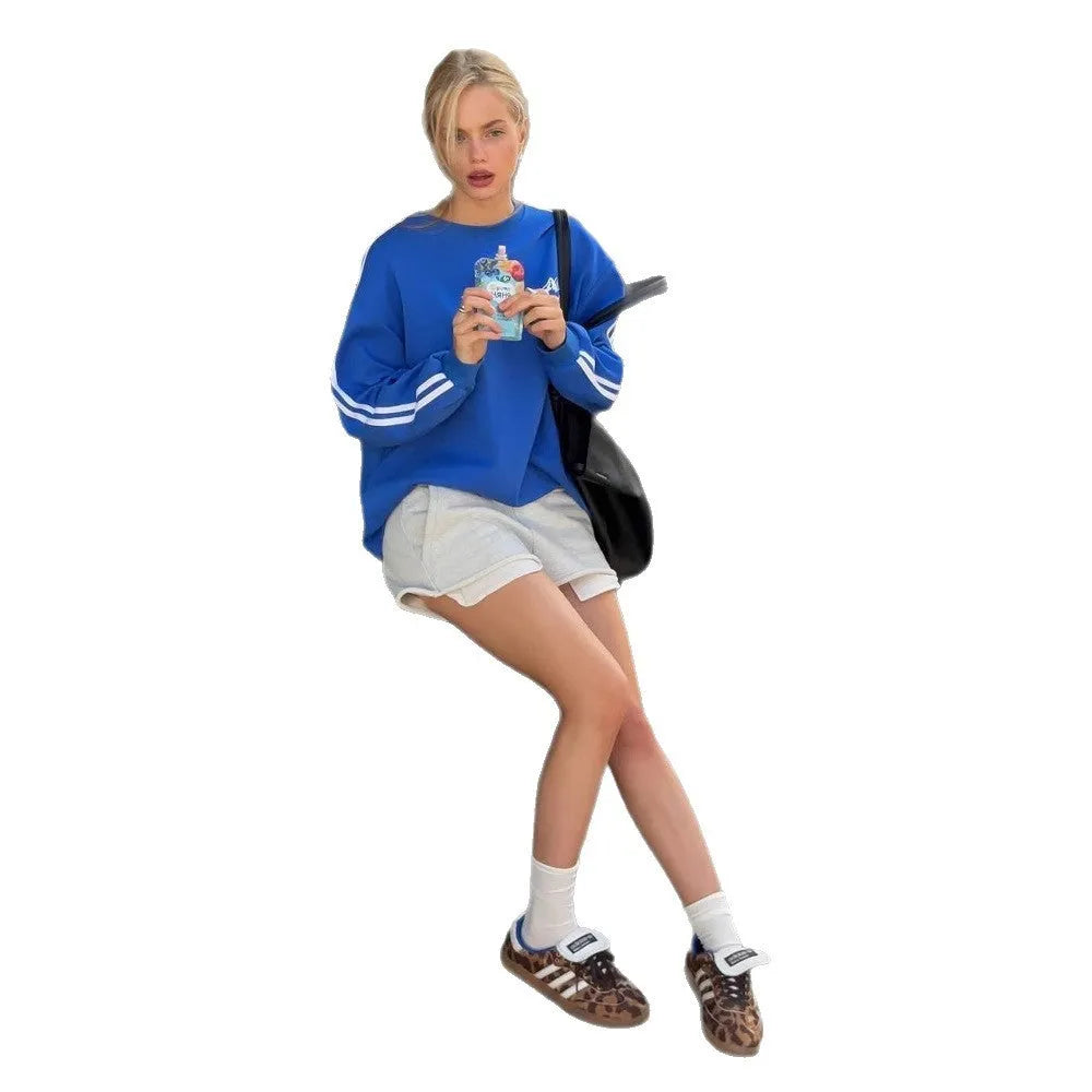 Blue vintage stripe loose-fit cotton sweater with round neck and long sleeves on a hanger.