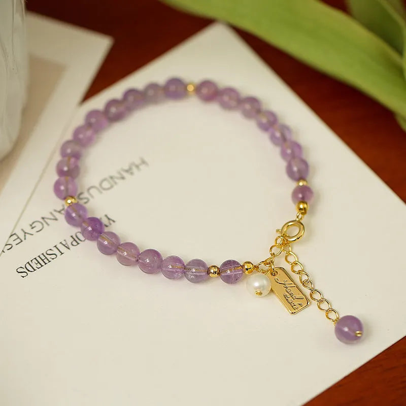 Women's natural crystal bracelet with lavender amethyst stones and animal zodiac design.