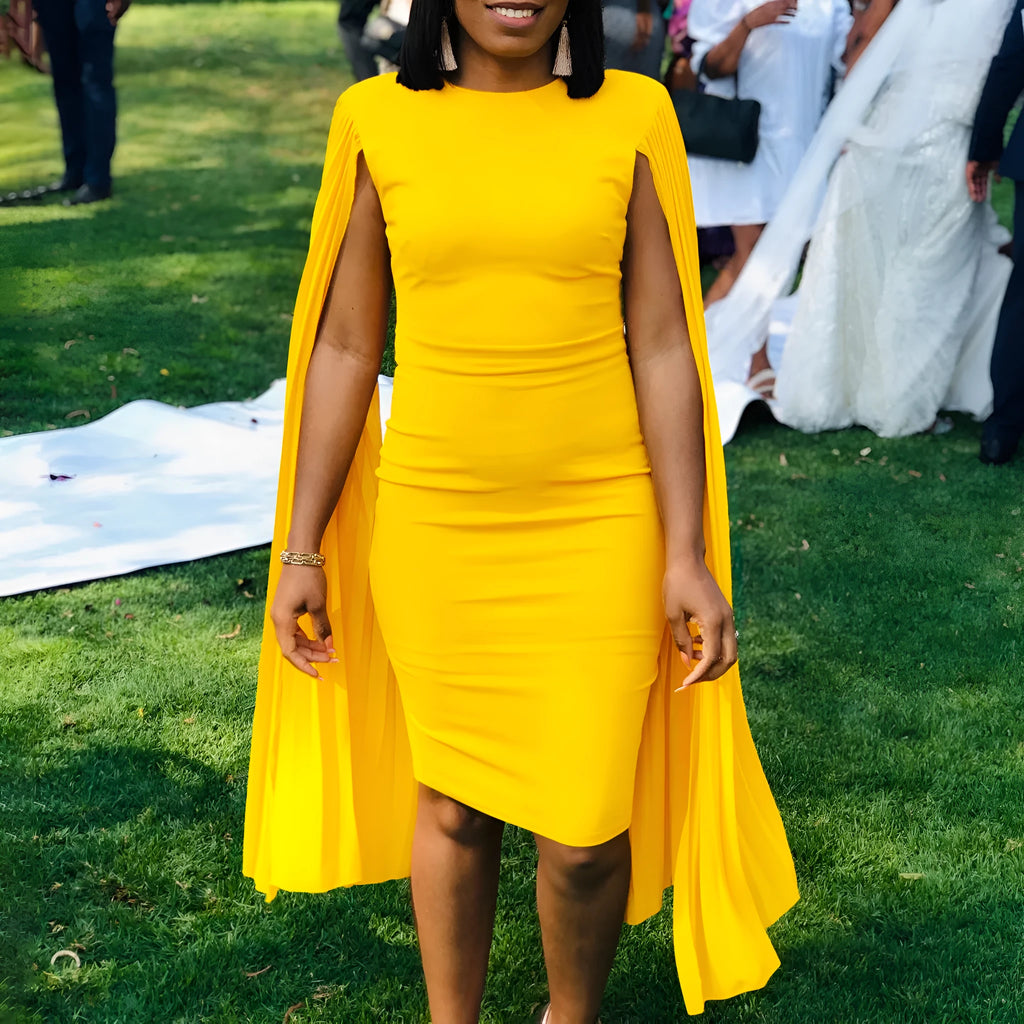 Yellow high-waisted evening gown with long sleeves and a pleated shawl detail at the neck.