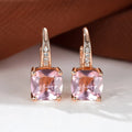 Geometric copper ear hook earrings with a round square zircon inlay, shown in a gold electroplated finish.