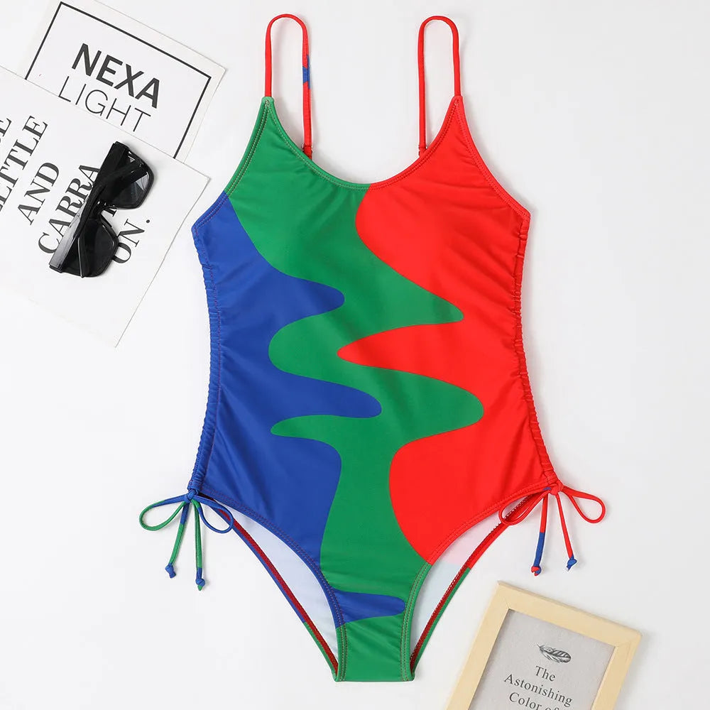 Women's blue sleeveless backless one-piece swimsuit on a hanger showing striped print detail.