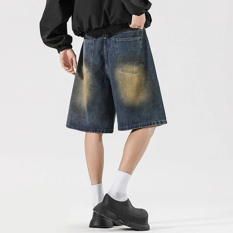 Man wearing loose fit retro blue ripped jeans with distressed details on knees and thighs