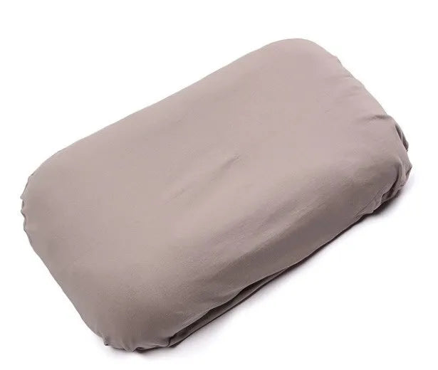 Beige portable cotton baby nest crib for newborns on a neutral background