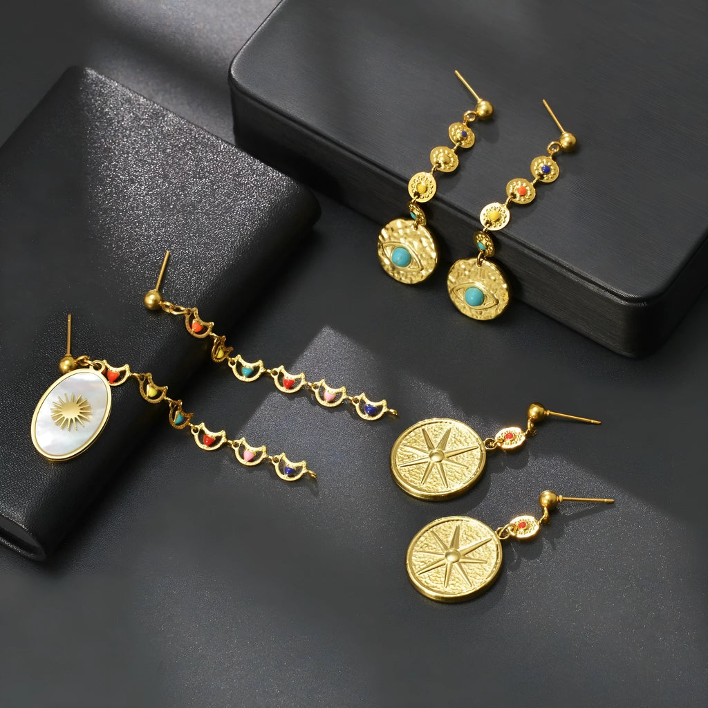 Three pairs of geometric stainless steel earrings showing Eight Awn Star, Eye, and Shell Sun designs