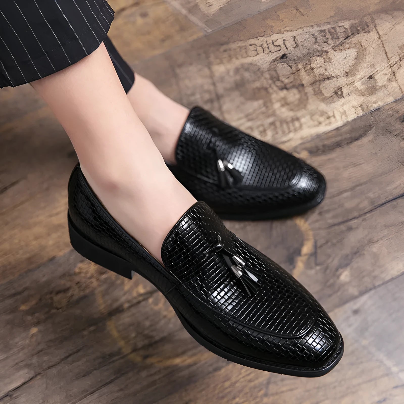 Men's black pointed toe slip-on shoes with a tassel detail on the low-top PU leather upper.