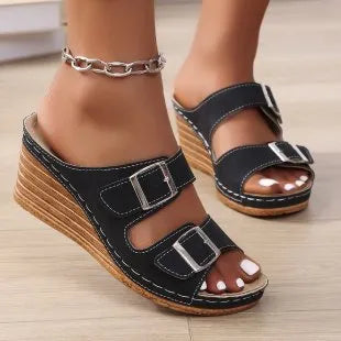Women's wedge slippers with an outer buckle closure in creamy-white colour on a rubber sole.
