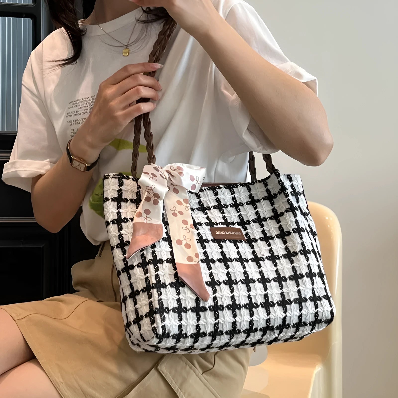 Wool blend shoulder bag in horizontal square shape with organisational compartments and woven sewing details