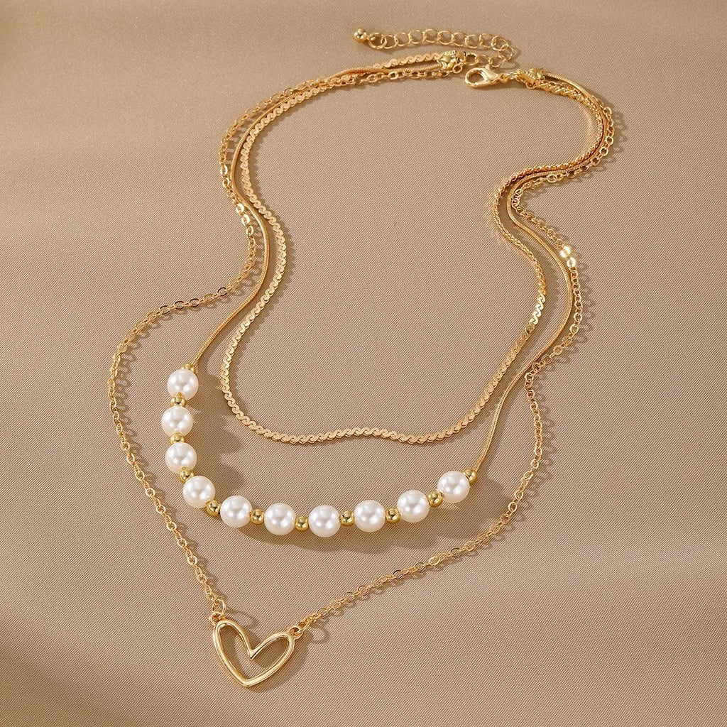 Vintage gold necklace with heart-shaped pendant on adjustable pearl-style chain