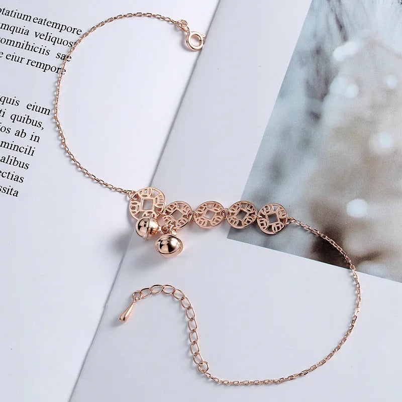 Rose gold stainless steel anklet with coin charms and small bells on adjustable link chain