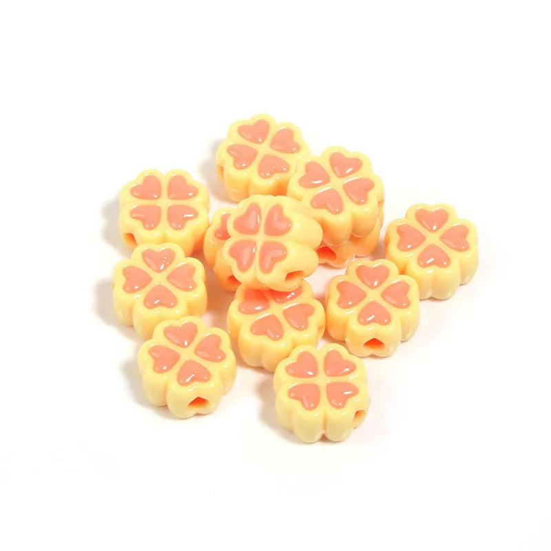 Frosted acrylic four-leaf clover shaped beads in mixed colours on white background