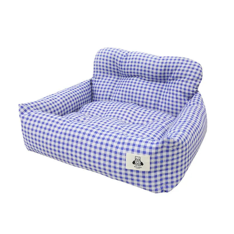 Blue plaid portable dog car bed nest with raised sides, shown on a vehicle seat.