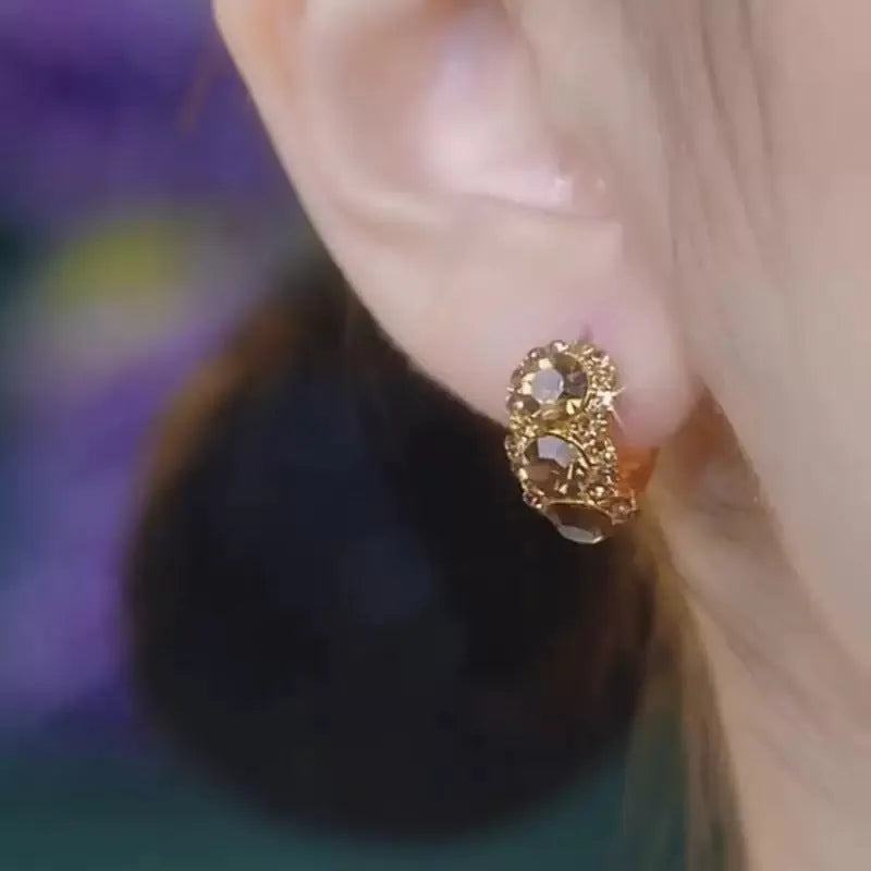 Gold metal hoop earrings with brown zircon stones in geometric shape
