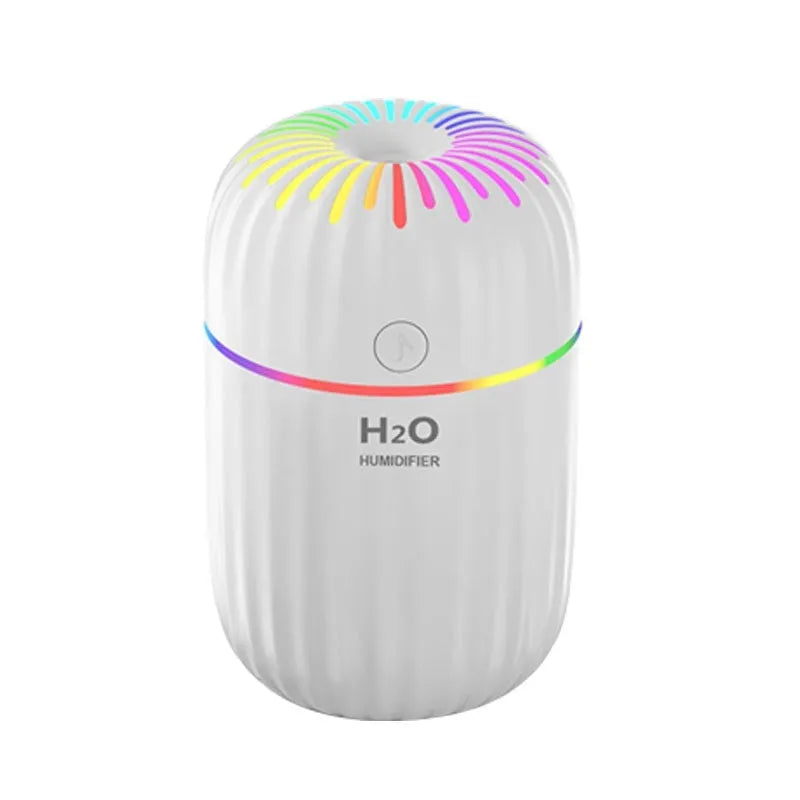 Fireworks A5 white mini USB humidifier with water tank on a wooden desk next to a laptop