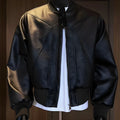 Men's black slim-fit PU leather jacket with extended length and litchi grain texture.
