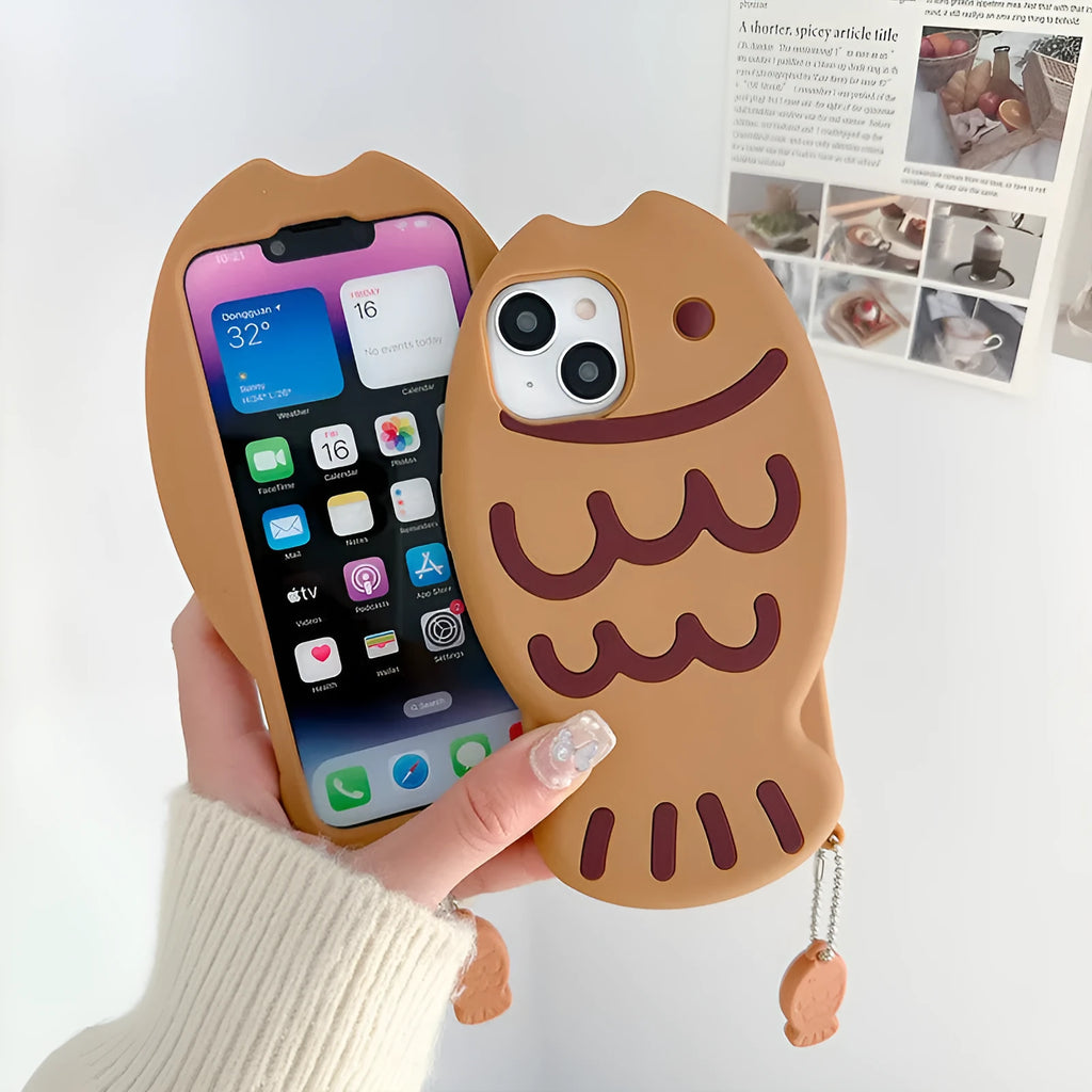Brown silicone phone case with 3D taiyaki design and hanging ornament for iPhone.