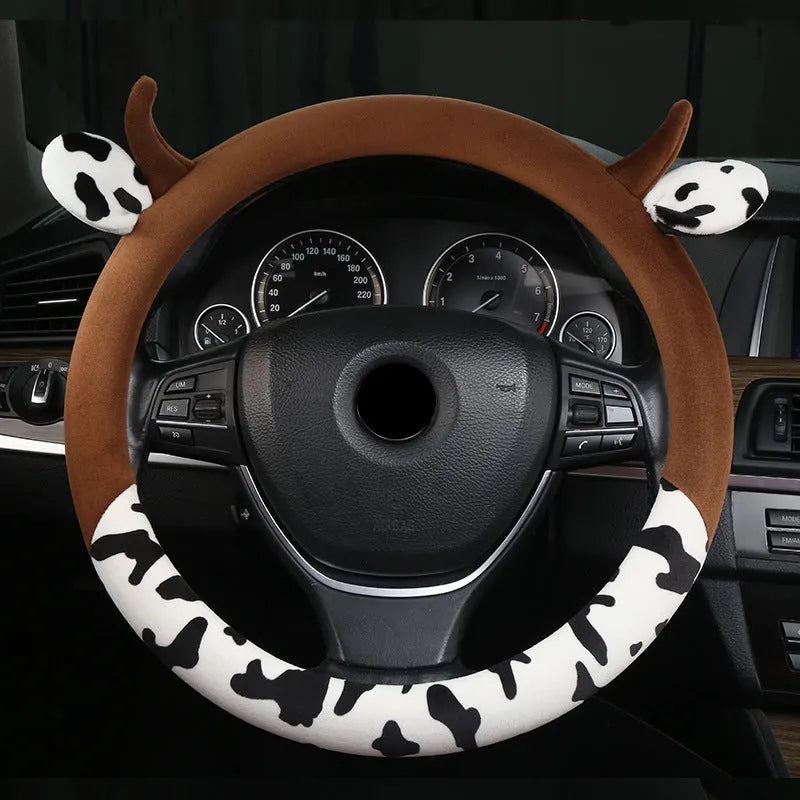 Short plush automotive steering wheel cover in black, showing protective handle detail.