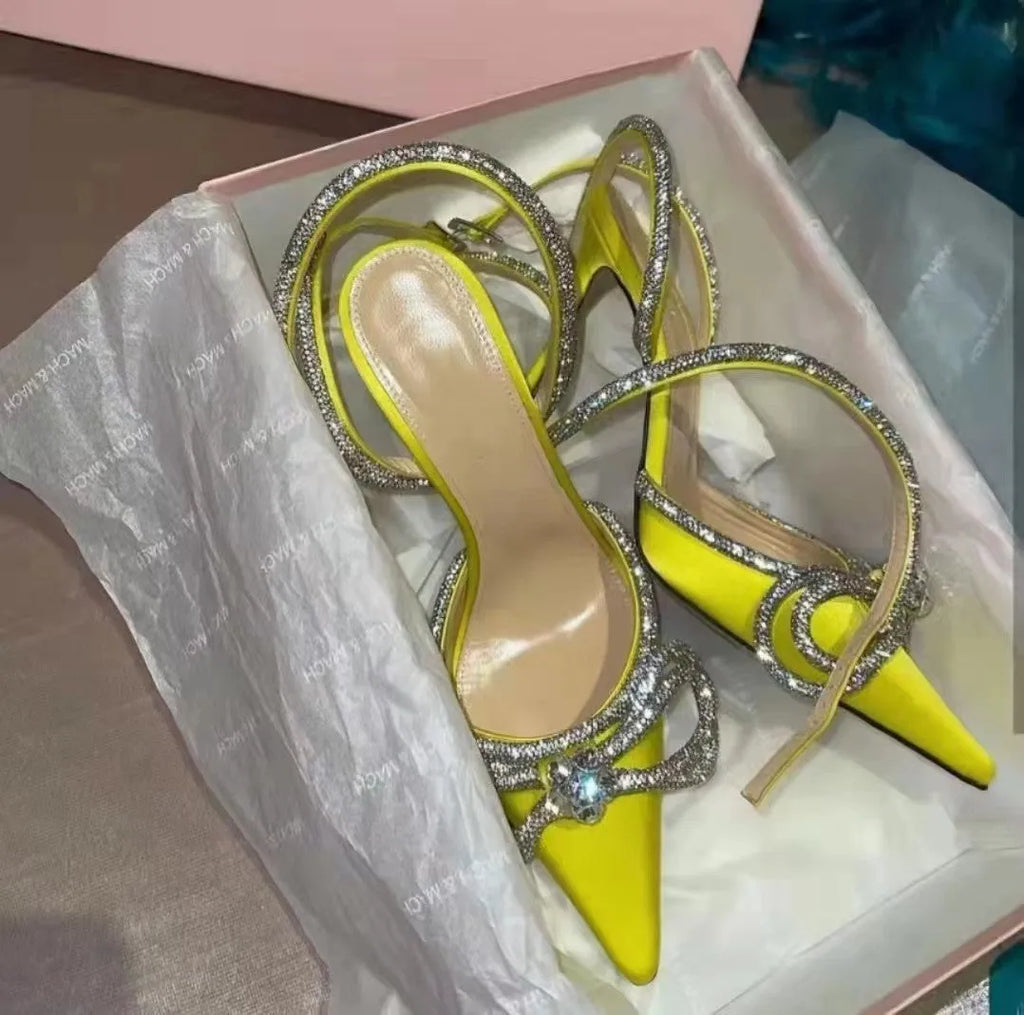Women's black stiletto sandals with silk-like bandage across heel and gold buckle closure.
