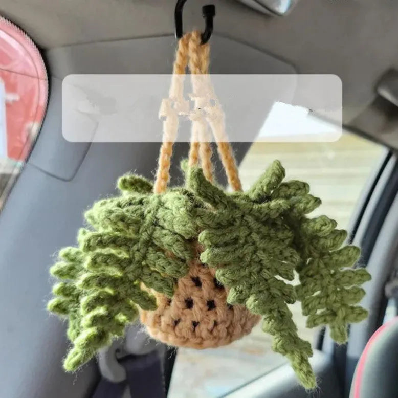 Green and white knitted wool car plant ornament with basin base and hanging rope.