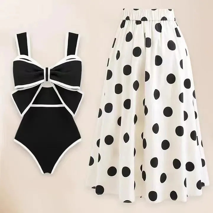 Women's black one-piece swimsuit with attached round skirt and decorative bow detail