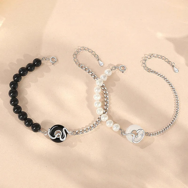 Close-up of a 925 sterling silver bracelet with a safe buckle, featuring obsidian pearls and a detailed snake charm in a new Chinese style.