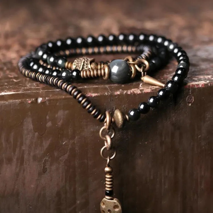Black multi-layered beaded bracelet with geometric shapes and colourful retro patterns