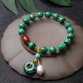 Natural green malachite bracelet with barrel-shaped beads on a wrist.