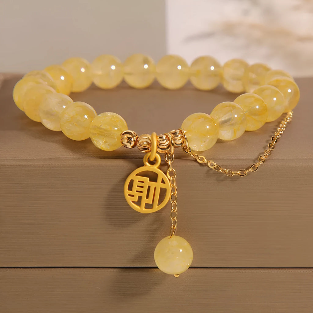 Women's natural citrine bracelet with gold electroplated Chinese character charm on an adjustable dark cord.