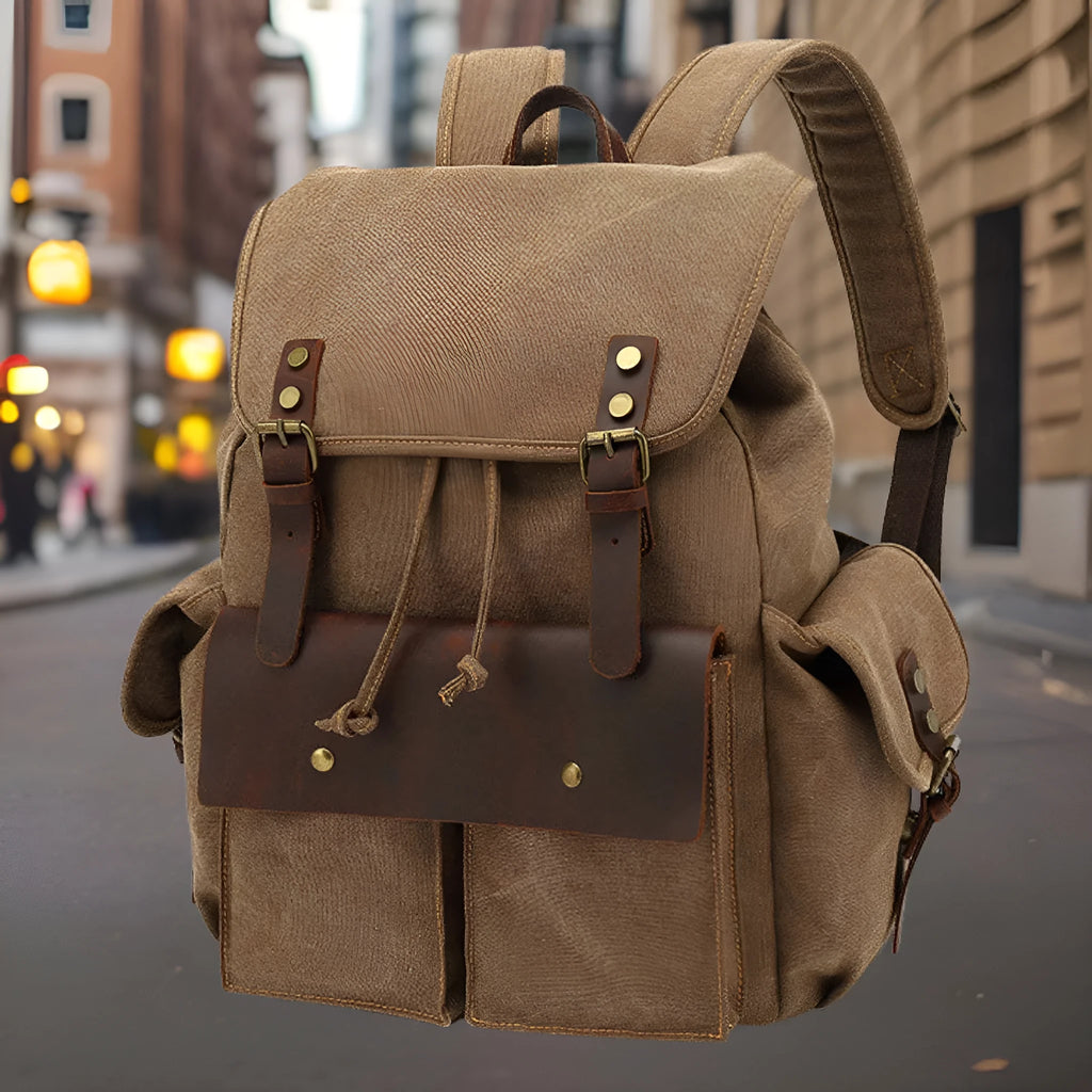 Retro military green canvas backpack with antique bronze hardware on a plain background.