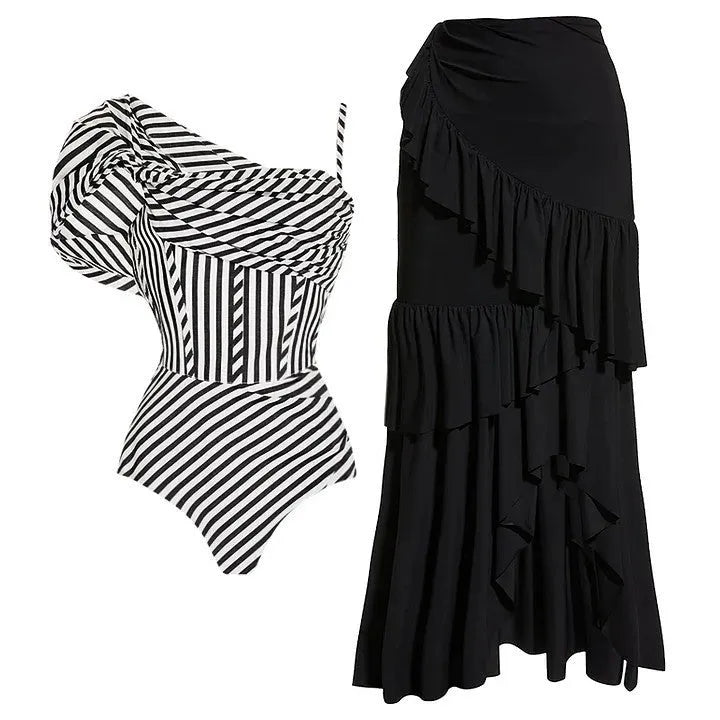 Woman wearing a striped one-piece swimsuit with a black ruffled skirt attached.
