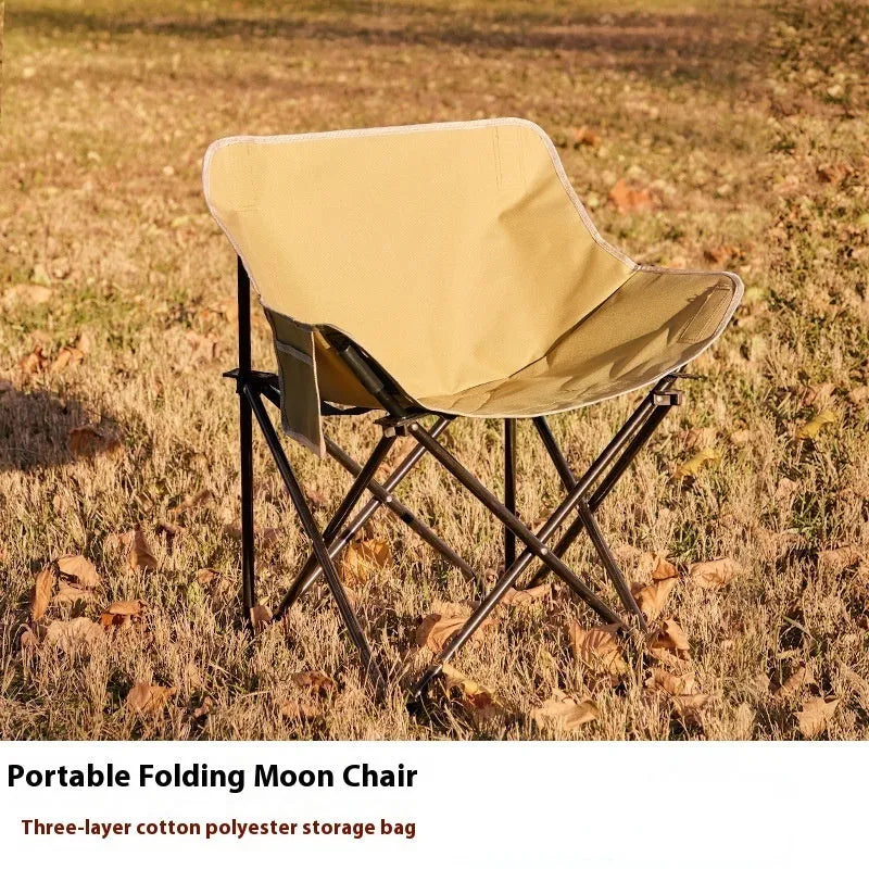 Beige portable folding camping chair with steel frame on grass outdoors
