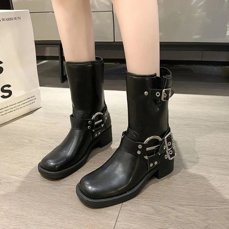 Women's black platform boots with buckle detailing showing middle calf length