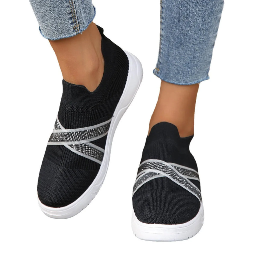 Black women's flat shoes with flyknit mesh upper, round toe, and tassel detail