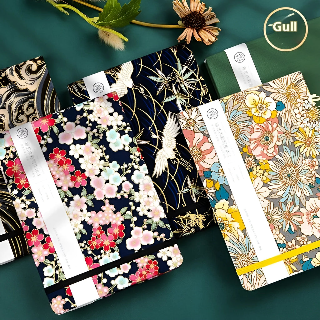 Feiluniao handmade fabric watercolour notebook open on a table with paintbrush.