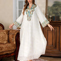 White polyester Arabic robe with long sleeves and full-length skirt on hanger