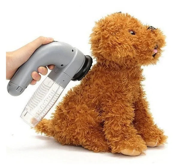 Grey portable pet hair vacuum cleaner with soft rubber grooming head on a fabric sofa