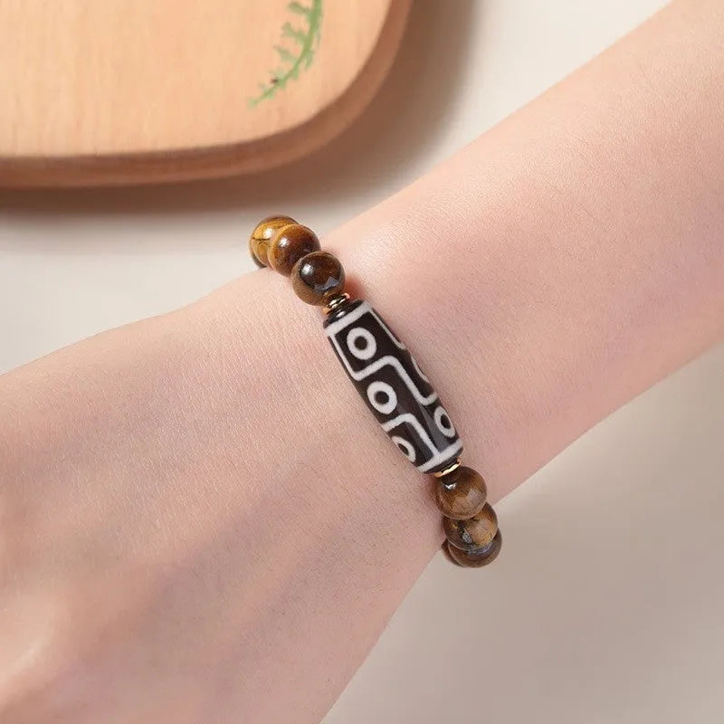 Ethnic style single circle bracelet with a patterned Tigereye Dzi bead on wrist.