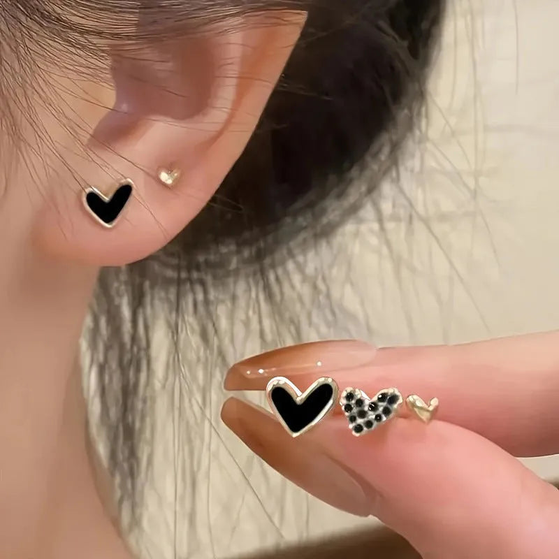 Three pairs of heart-shaped alloy earrings with electroplated finishes in gold, black, black-white, and pink colours
