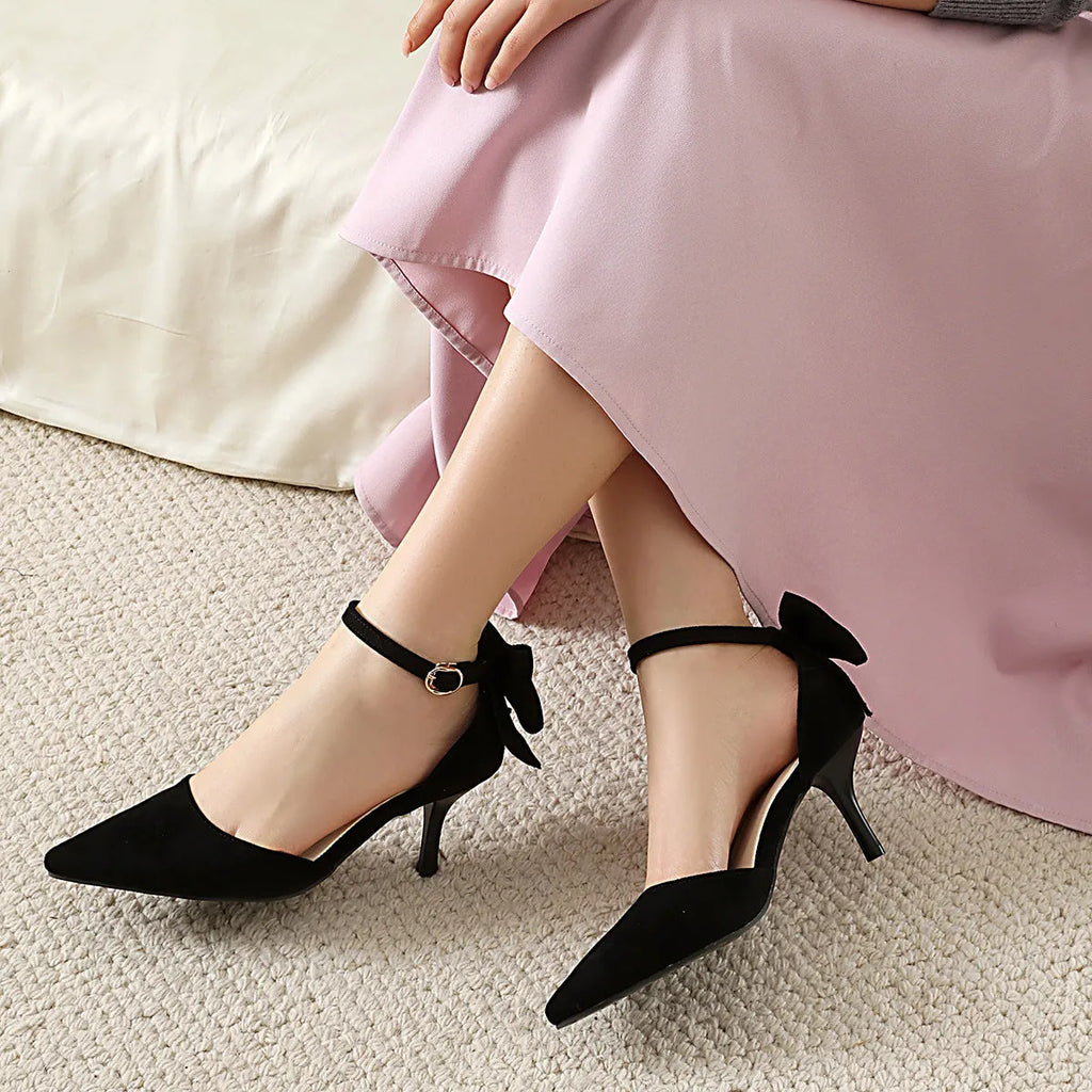 Women's black stiletto heels with pointed toes, bowknot detail and buckle closure