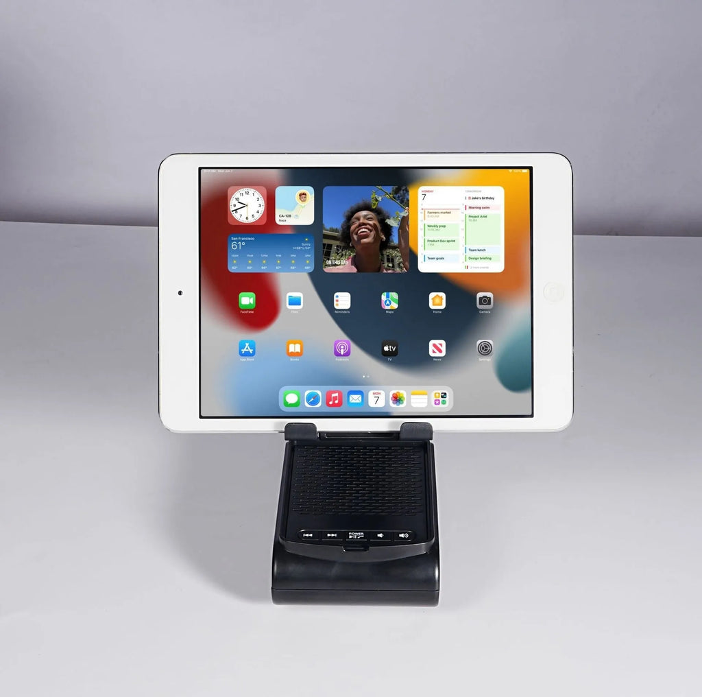 Multi-function lazy phone holder with Bluetooth audio in black plastic on a desk showing a smartphone in landscape mode