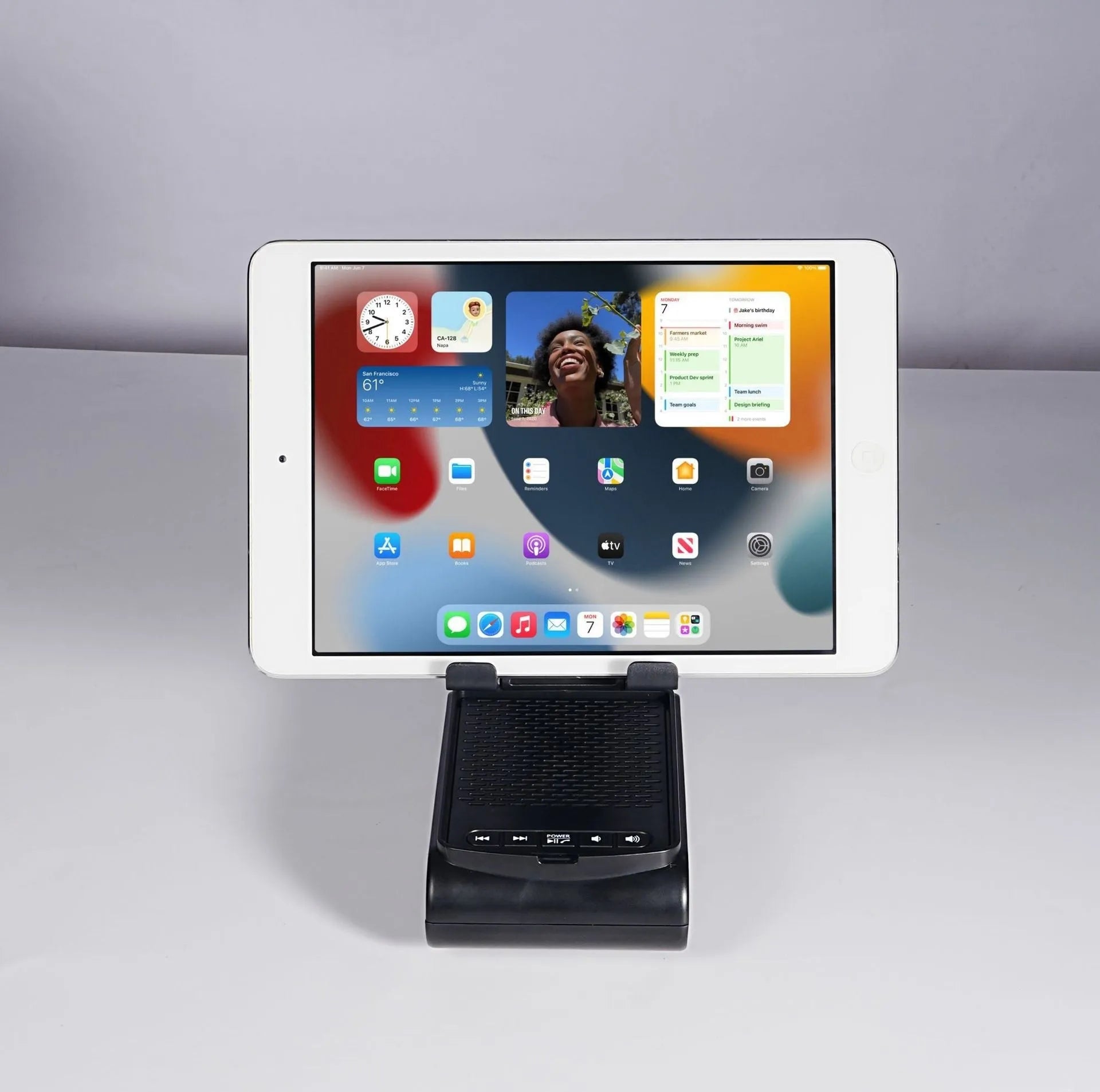 Multi-function lazy phone holder with Bluetooth audio in black plastic on a desk showing a smartphone in landscape mode
