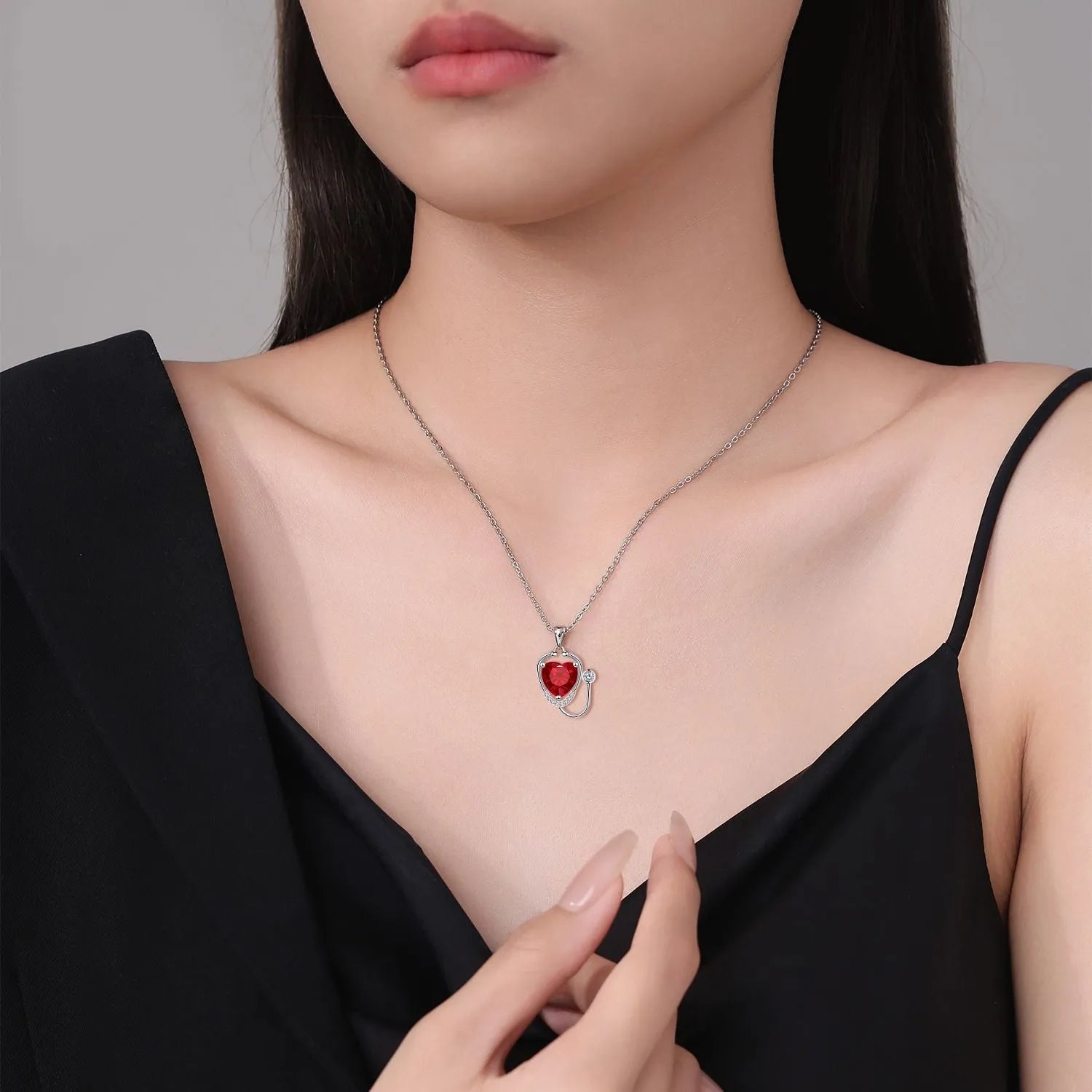 Women's copper necklace with a red diamond electroplated pendant showing stethoscope, wings, and cross design.